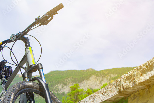 close-up details of a bicycle against a background of forest and lake, foreground and background blurred with bokeh effect