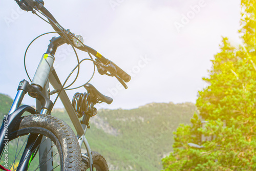 close-up details of a bicycle against a background of forest and lake, foreground and background blurred with bokeh effect