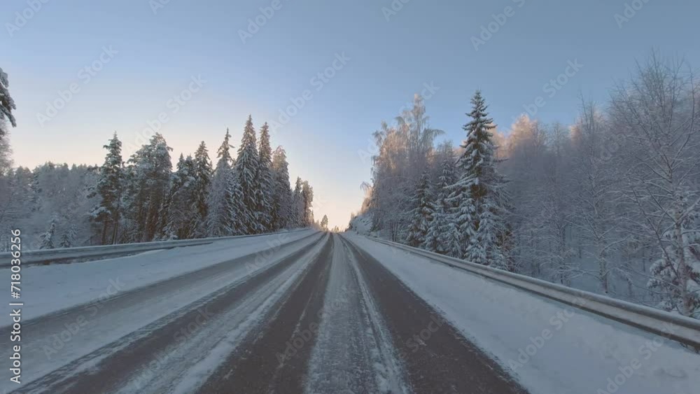 Winter driving POV through scenic forest landscape with dazzling sunlight Winter driving POV through scenic forest landscape with dazzling sunlight