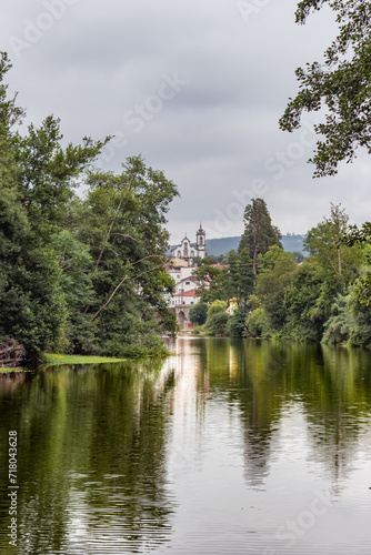 Moving water with colorful reflection of trees on the banks of the river Alva and buildings in Côja in the background, PORTUGAL photo