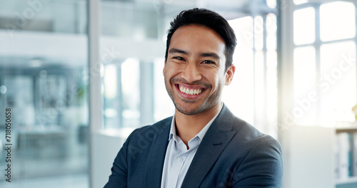 Asian business man, arms crossed and face in office, smile and pride for leadership, management and professional. Financial advisor, businessman and happy in portrait, suit and ambition in workplace photo