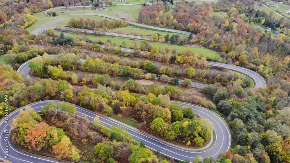 Curves of winding road through autumn forest in rural Poland aerial panorama Curves of winding road through autumn forest in rural Poland aerial panorama