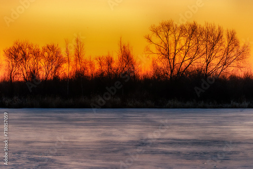 North-eastern European river after frosty winter. Porous ice began to melt, river is swollen, state of ice week before ice break (ice-boom). Aurora, sunrise colors on a spring moning
