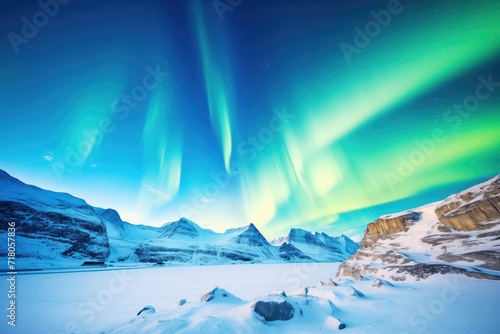 dramatic view of a bright aurora above glacier-covered mountains © Natalia