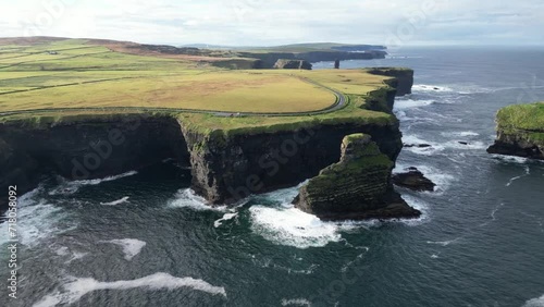 Coastal panoramic road along Kilkee high cliffs, Ireland. Aerial forward descending toward rocky coast photo