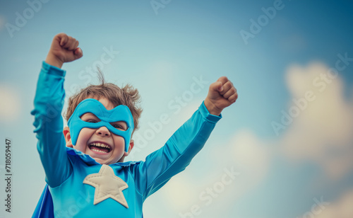 A little superhero in a blue cape with a star. A happy smiling child with glasses, ready to learn. Success, the concept of motivation. Back to school. Little businessman isolated against sky backgroun