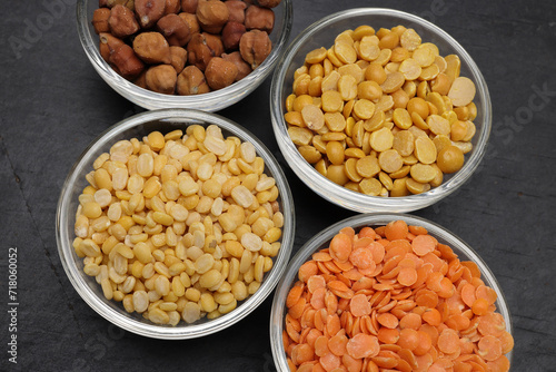 variety of lentils pulses red masoor mung dal yellow split chickpeas pigeon peas in mini glass bowl on black slate background