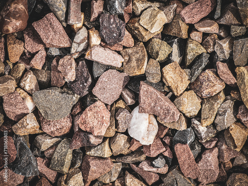 close-up of a gritty texture formed by a mixture of gravel and various stones.Smooth round pebbles texture background. 