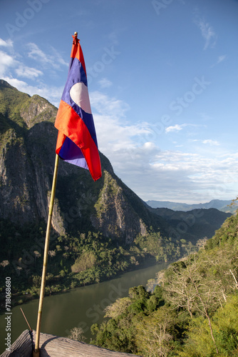 Laotian flag on top of viewpoint with the Nam Ou river and a canyon