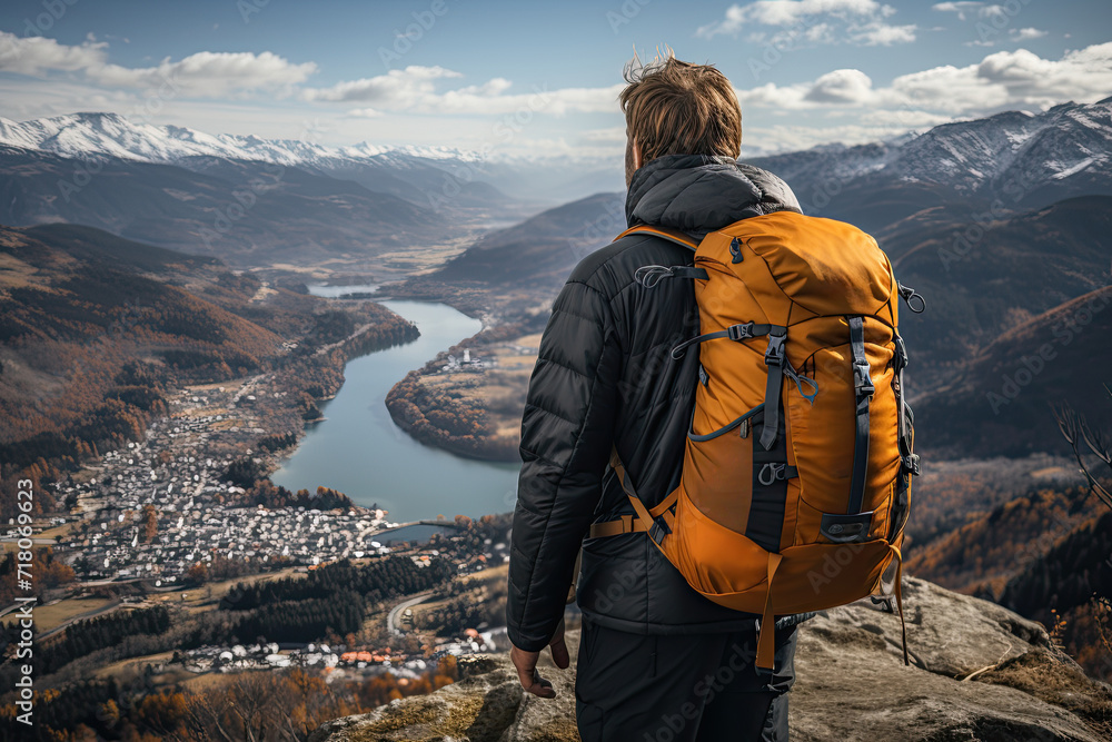 Man with backpack standing on the top of mountain and enjoying the view. Travel concept. Hiking Man with backpack standing on the top of mountain and enjoying the view. Travel concept. Hiking