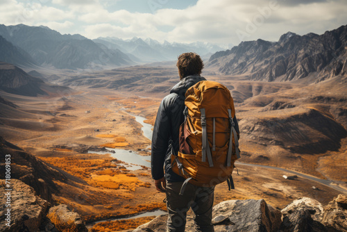 Man with backpack standing on the top of mountain and enjoying the view. Travel concept. Hiking