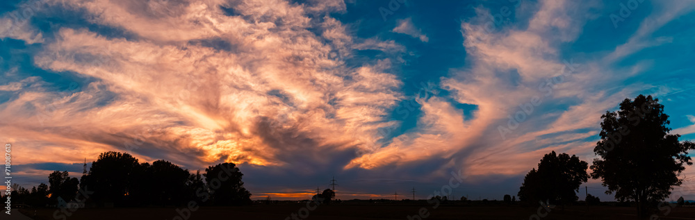 High resolution stitched summer sunset panorama with dramatic clouds near Tabertshausen, Deggendorf, Bavaria, Germany