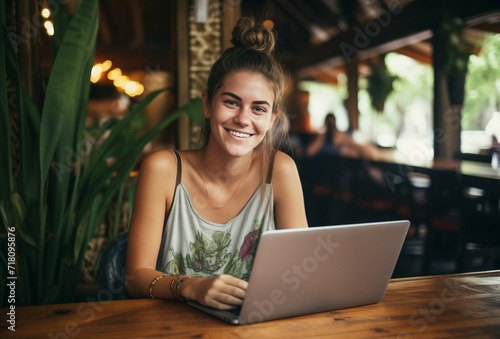 Smiling Young Woman Freelancer Working Remotely on Laptop in Asian Cafe