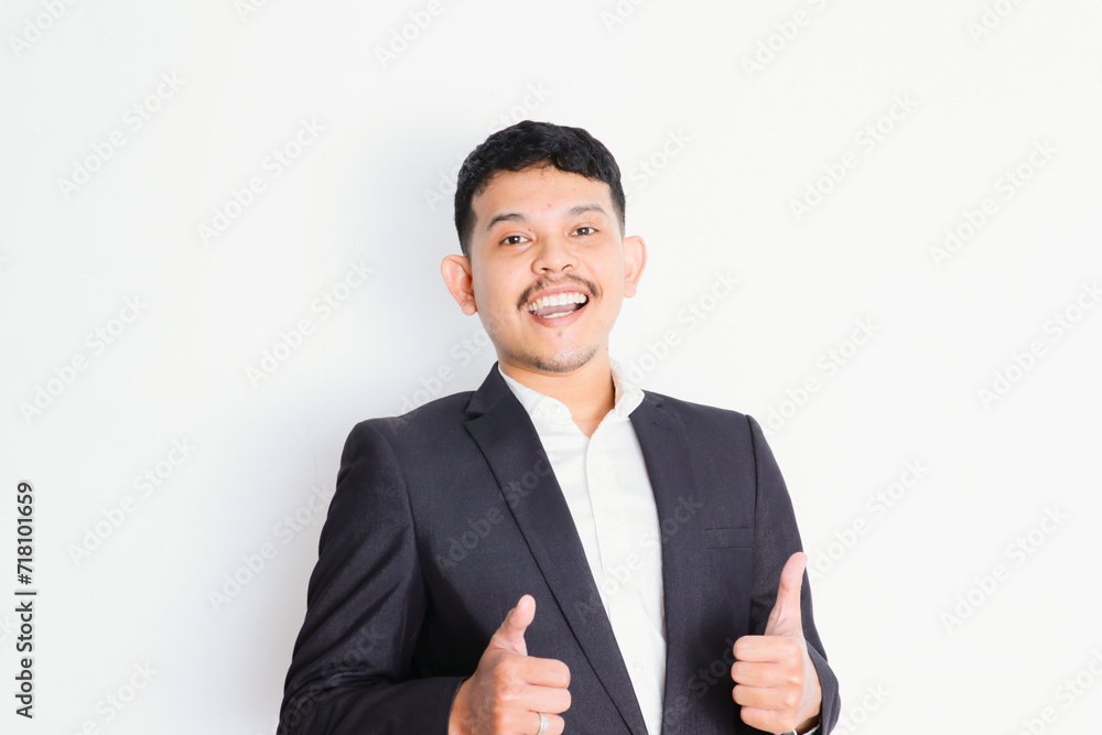 a young asian businessman stands and shows a gesture of pride and success a young asian businessman stands and shows a gesture of pride and success