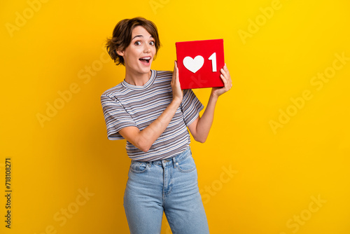 Photo of impressed optimistic woman with bob hairdo dressed striped t-shirt get one social media like isolated on yellow color background