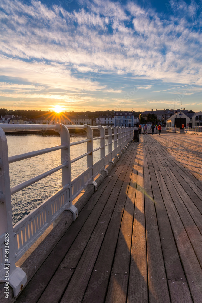 Vibrant sunset casting golden light over Beaumaris Pier in North Wales - United Kingdom