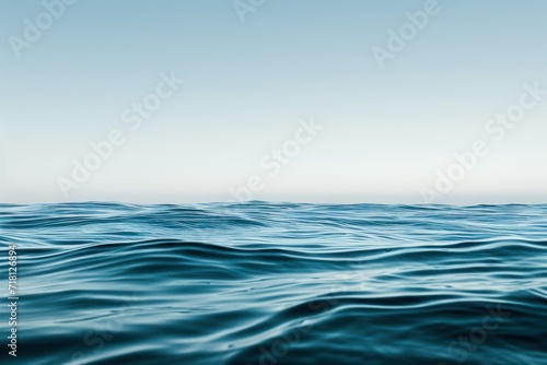 a flat and smooth water wave with blue sky over it