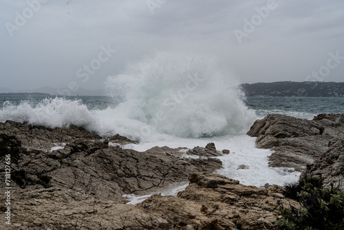 Waves crashing during storm on a rocky shore. High quality photo. Climate natural event weather