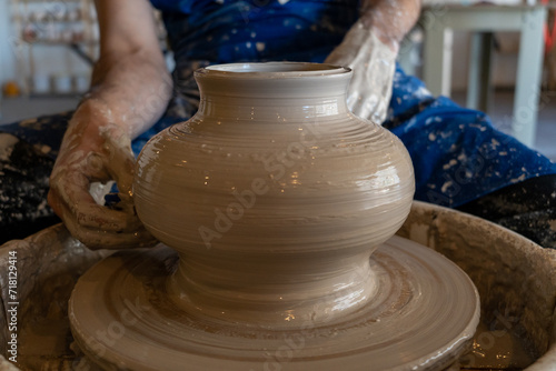 Potter throwing a pot on the wheel in a studio. High quality photo. Hobby, side hustle, activity