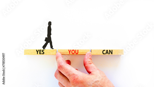 Motivational and Yes you can symbol. Concept words Yes you can on beautiful wooden blocks. Beautiful white background. Businessman hand. Business motivational and Yes you can concept. Copy space.