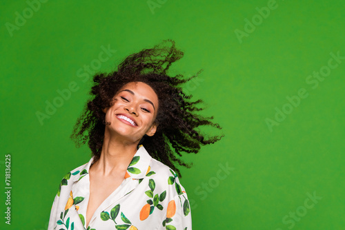 Photo of carefree sweet woman dressed print shirt having fun dancing empty space isolated green color background