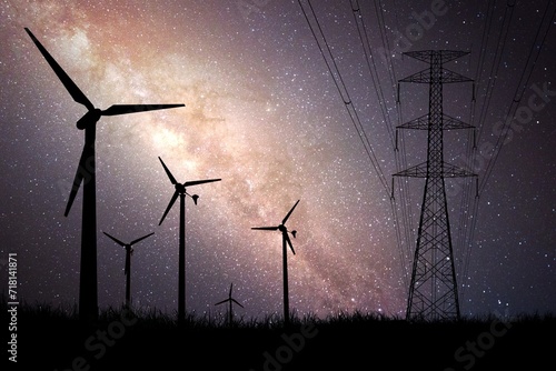 Wind turbine silhouettes are used to generate electricity in the fields during the evening hours.