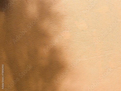 In the picture, there is an orange wall with light shining on the wall in various shapes. It looks like an art of light and shadow. It has a soft orange color, the light of the morning sun one day.