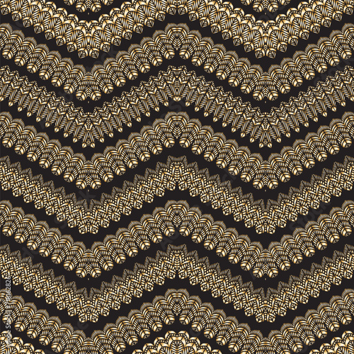 Vector zig-zag seamless pattern with stylized bird feathers. Golden waves, gold tribal ornaments on a black background photo