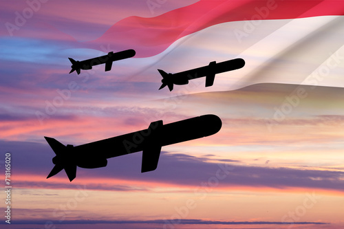 Silhouettes of Tomahawk cruise missiles with Yemen flag against the sunset