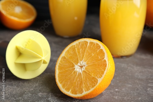 Принти на полотні Cut fresh ripe orange, reamer and juice on grey table, closeup