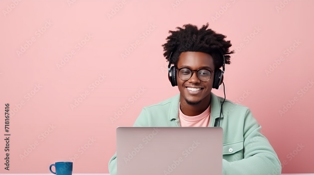 A joyful young man is working at a laptop and talking on a headset against the background of a plain wall. Concept: home office, telecommunications and customer support. Copy space
A joyful young man is working at a laptop and talking on a headset against the background of a plain wall. Concept: home office, telecommunications and customer support. Copy space