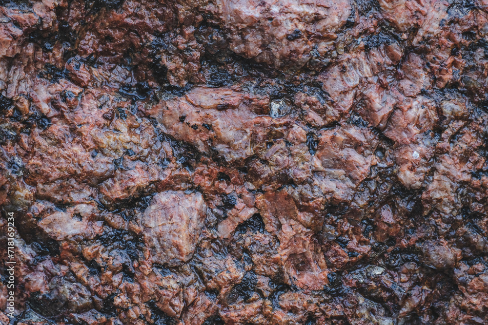 Surface of red big grained rough granite rock as an abstract background.