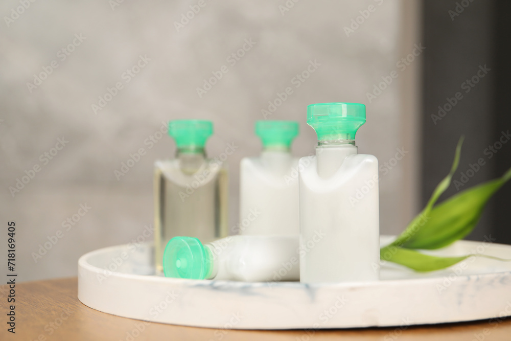 Mini bottles of cosmetic products on table, closeup. Space for text Mini bottles of cosmetic products on table, closeup. Space for text