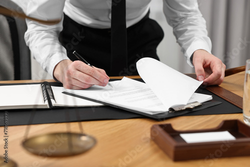 Lawyer working with documents at wooden table indoors, closeup © New Africa