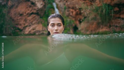 Portrait swimming woman posing lagoon water. Seductive lady stretching to camera