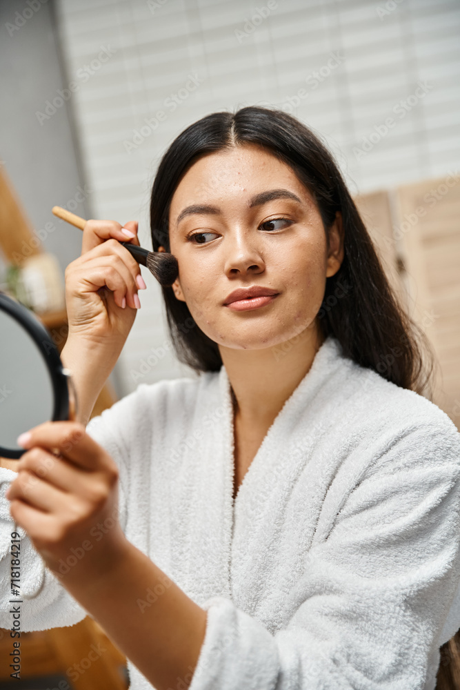 young asian woman with brunette hair applying makeup over acne-prone skin with cosmetic brush young asian woman with brunette hair applying makeup over acne-prone skin with cosmetic brush