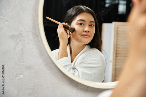 Foto brunette young asian woman applying face powder over acne-prone skin with brush
