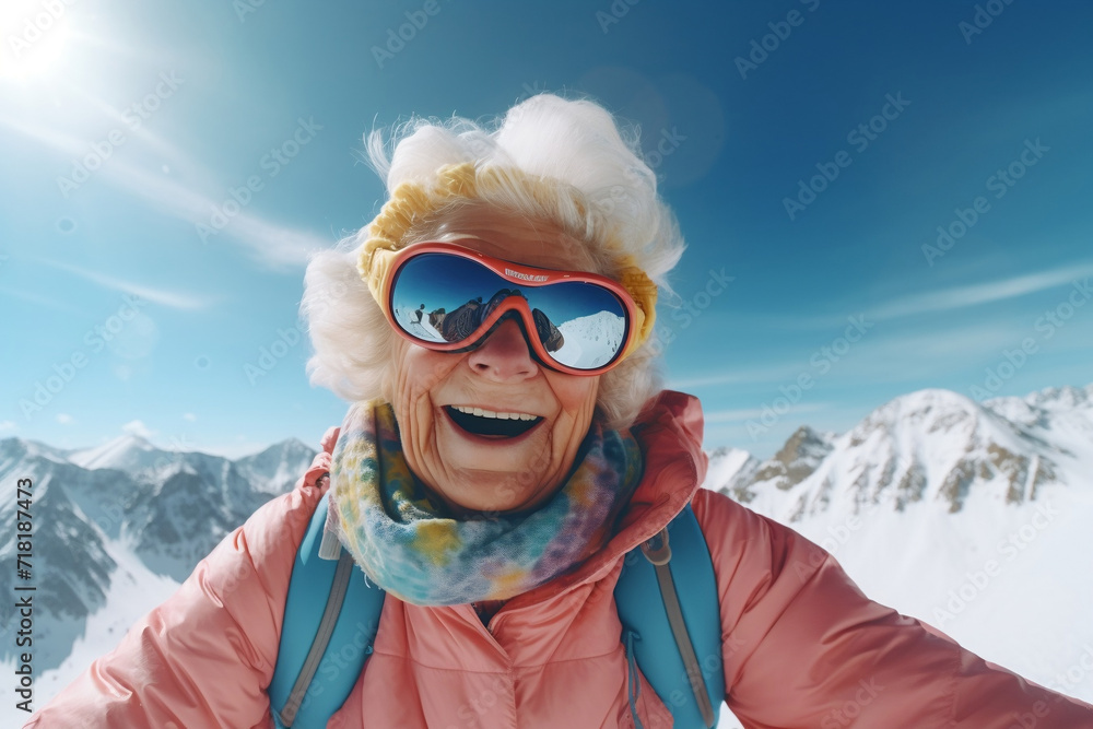 close-up of a happy laughing elderly grandmother with gray hair wearing glasses, takes a selfie in the mountains in winter. Winter fun. Grandmother snowboarding in the mountains