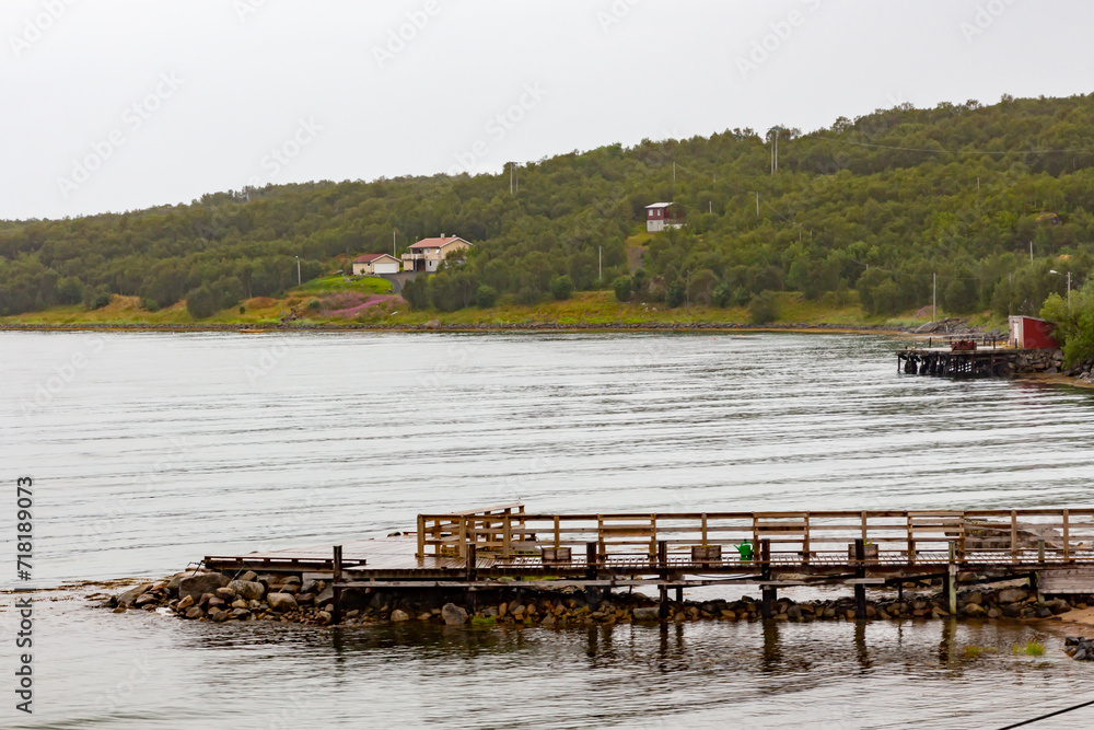 Wooden jetty with green mountains in the background