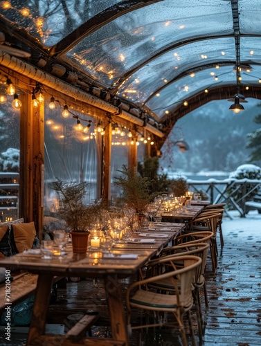 A cozy winter dinner awaits at an outdoor restaurant  with a beautifully lit wooden dining table and chairs set against a snowy backdrop
