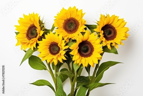  a vase filled with yellow sunflowers on top of a white table next to a vase filled with green leaves and a vase filled with yellow sunflowers.