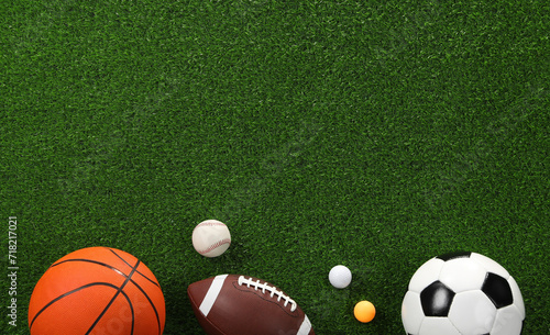 Many different sports balls on green grass, flat lay. Space for text © New Africa