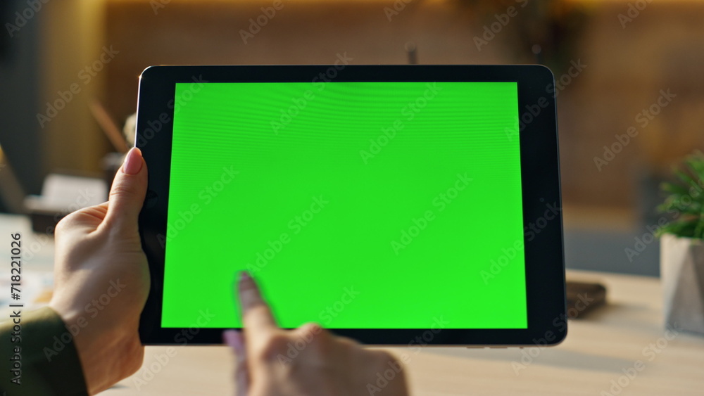 Freelancer hands swiping green screen tablet searching information at workplace. Freelancer hands swiping green screen tablet searching information at workplace.