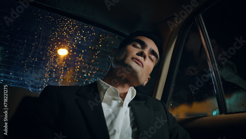 Sleeping man relaxing rainy window car close up. Tired businessman napping alone © stockbusters