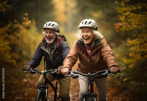 An elderly couple smiling and cycling together through a picturesque autumnal forest, embodying active aging