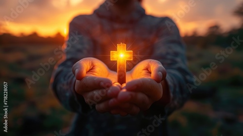 Hands holding a crucifix, a believer praying with his arms crossed, Jesus Christ, divine light from heaven