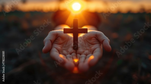 Hands holding a crucifix, a believer praying with his arms crossed, Jesus Christ, divine light from heaven