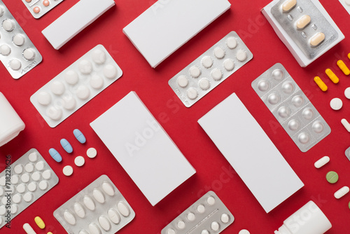 Different pills in blister packaging and boxes and on color background, top view photo