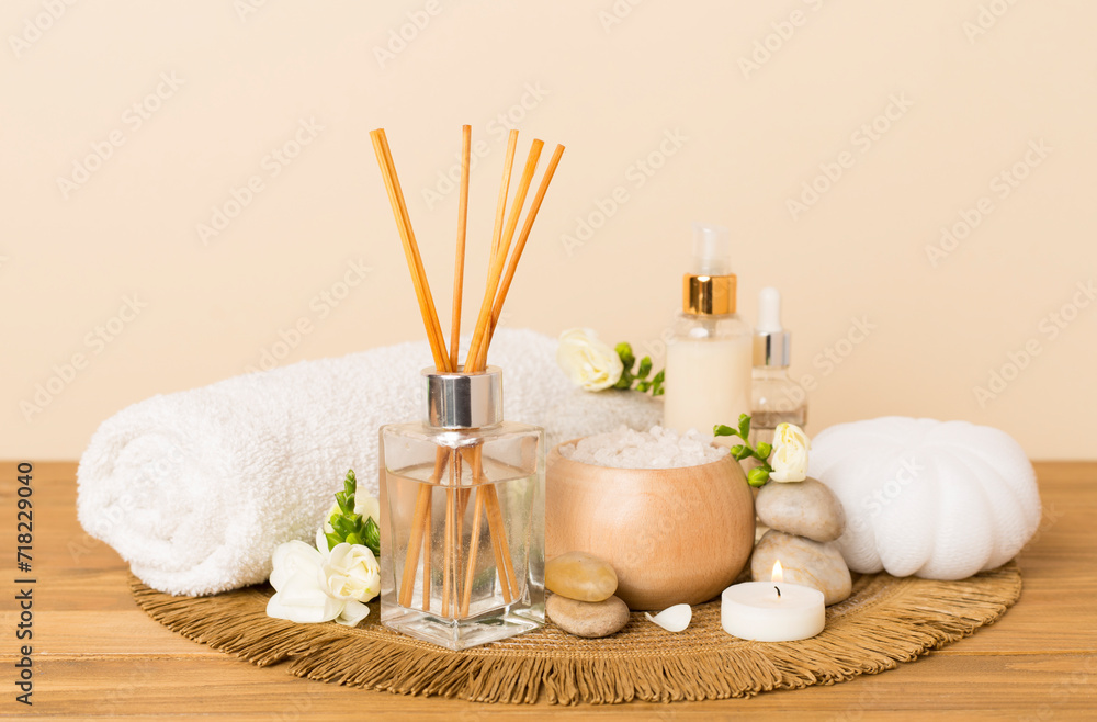 Spa composition with freesia flower and aroma diffuser on wooden table