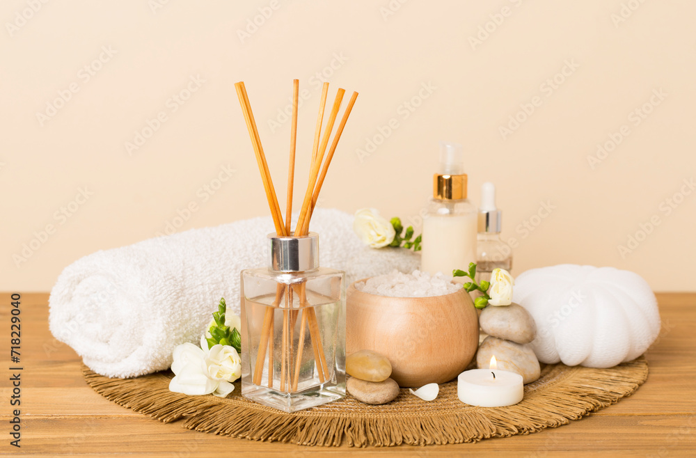Spa composition with freesia flower and aroma diffuser on wooden table Spa composition with freesia flower and aroma diffuser on wooden table